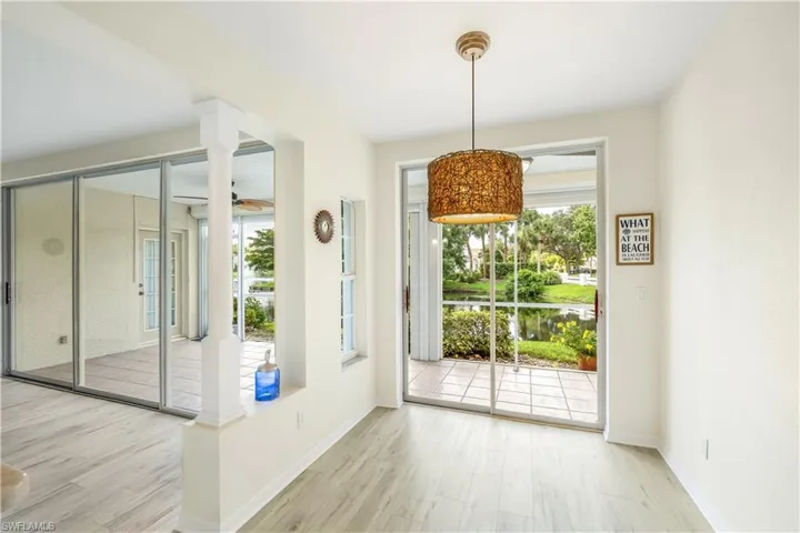 Dining/Eat-in Kitchen area featuring new LTV flooring and a doorway to outside screened lanai area.