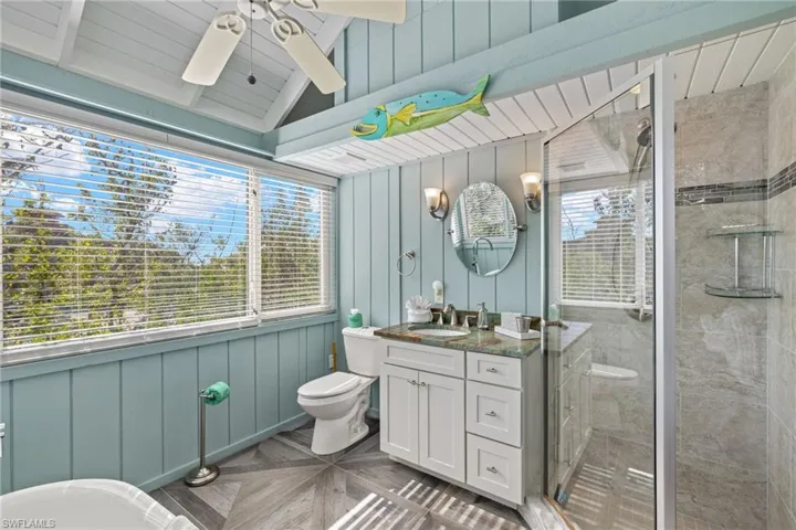 Bathroom featuring vanity, a healthy amount of sunlight, and a shower with door
