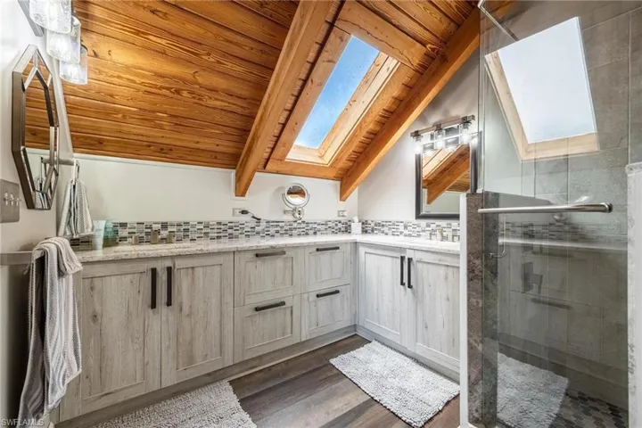 Upstairs Master Bathroom with tasteful backsplash, a shower with door, wooden ceiling, and hardwood / wood-style floors