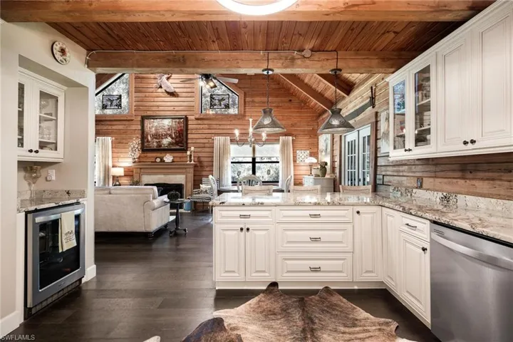Kitchen featuring dark hardwood / wood-style floors, hanging light fixtures, beverage cooler, dishwasher, and wooden ceiling