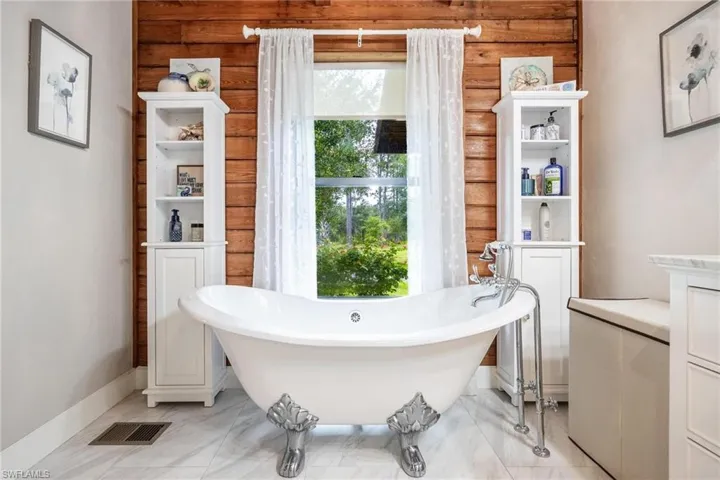Downstairs Master Bathroom featuring a washtub and tile patterned floors