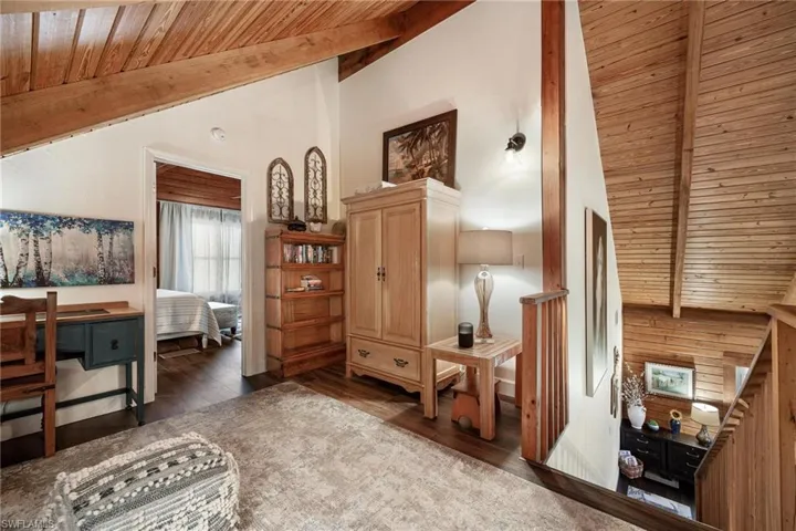 Loft seating area with wood ceiling, beam ceiling, and dark hardwood / wood-style floors.
