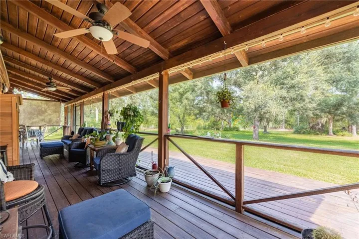 Spacious Screened Lanai featuring ceiling fan, an outdoor living space, an extended deck, and a beautiful lawn.