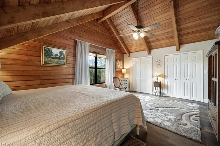Upstairs Master Bedroom featuring beamed ceiling, two closets, wood-type flooring, ceiling fan, and wood ceiling