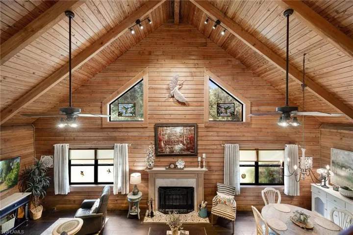 Living room featuring wood walls, wooden ceiling, and beamed ceiling