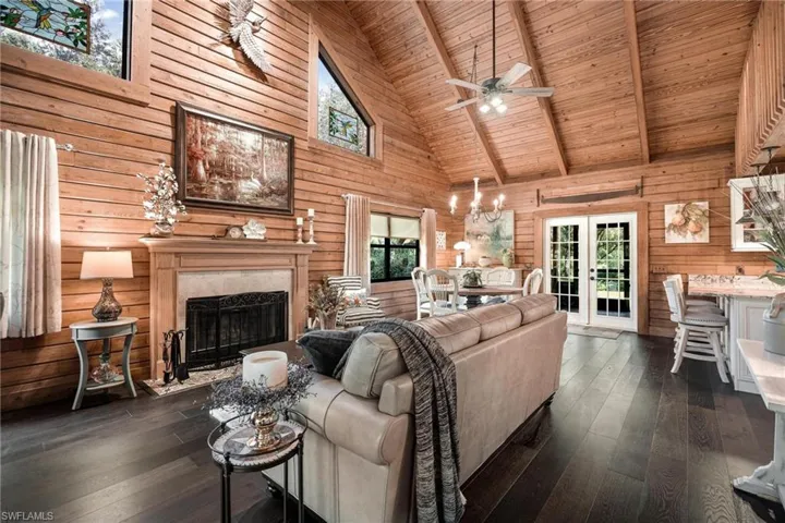 Living room with dark hardwood / wood-style floors, high vaulted ceiling, wood ceiling, and beam ceiling