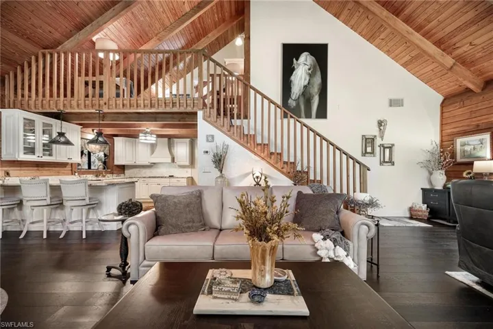 Living room featuring high vaulted ceiling, beam ceiling, dark hardwood / wood-style floors, and wood ceiling