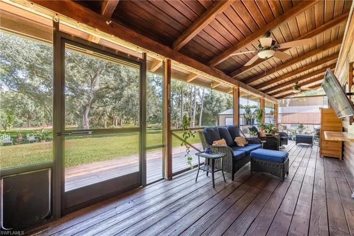 Sunroom featuring wood ceiling, ceiling fan, and vaulted ceiling with beams