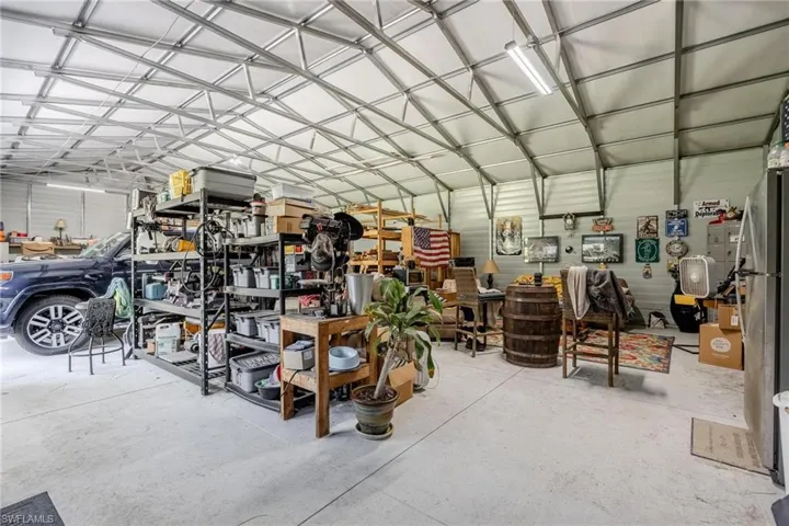 Garage with a workshop area and stainless steel refrigerator