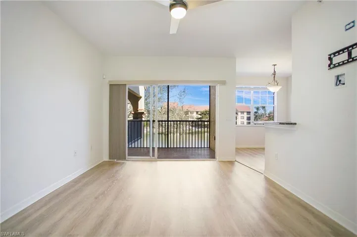 Empty room with wood finished floors, healthy amount of natural light, and baseboards