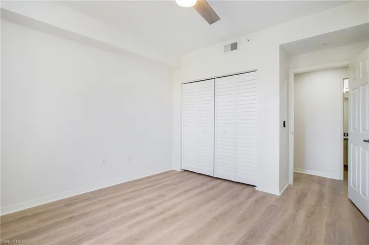 Unfurnished bedroom with light wood finished floors, a closet, baseboards, and ceiling fan