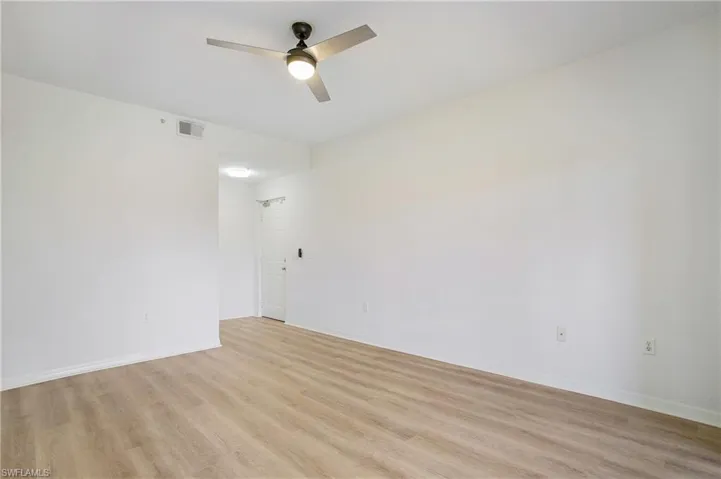 Empty room featuring a ceiling fan, light wood-style floors, and baseboards