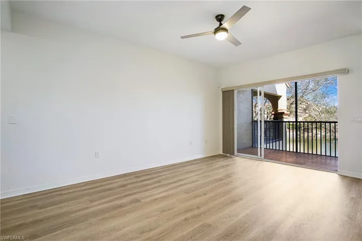 Empty room with wood finished floors, baseboards, and a ceiling fan