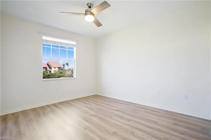 Unfurnished room with light wood-type flooring, ceiling fan, and baseboards