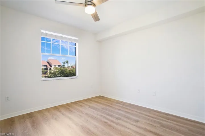 Empty room with light wood-style flooring, a ceiling fan, and baseboards