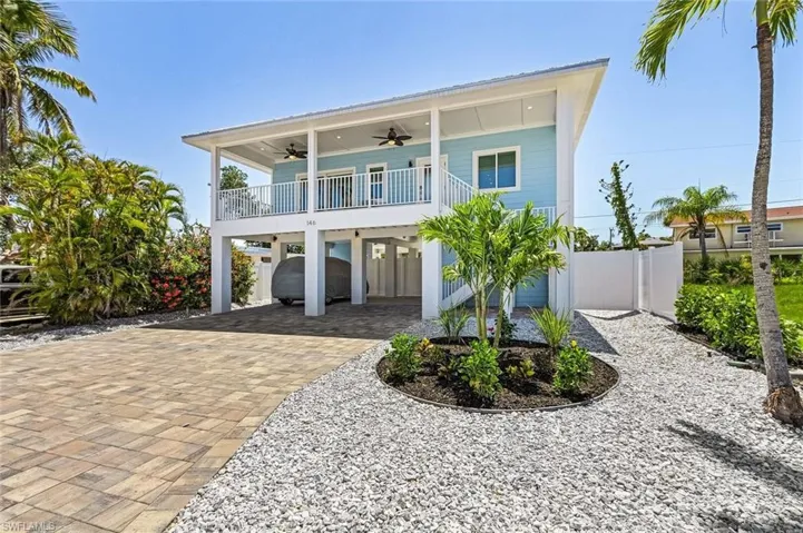 Front of house featuring a carport, a ceiling fans, driveway, and a balcony