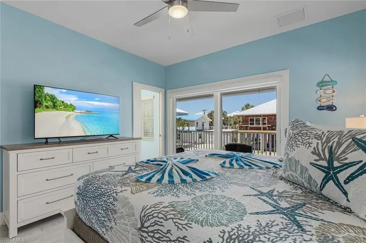 Bedroom with en suite, access to outside, and beachy decor