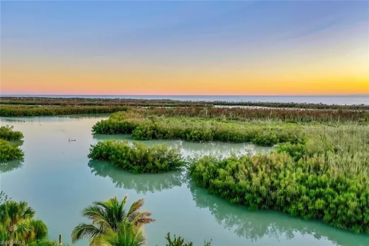 Aerial view at dusk featuring a water view