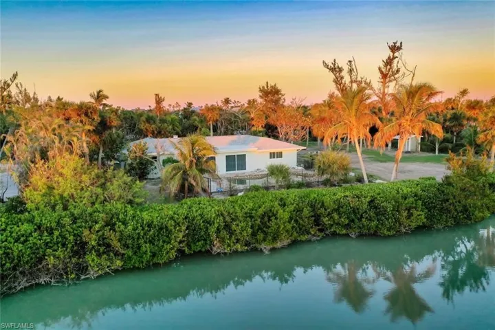 Aerial view at dusk featuring a water view