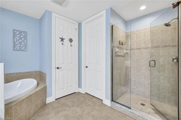 En suite master bathroom with separate shower, tub, and toilet room.