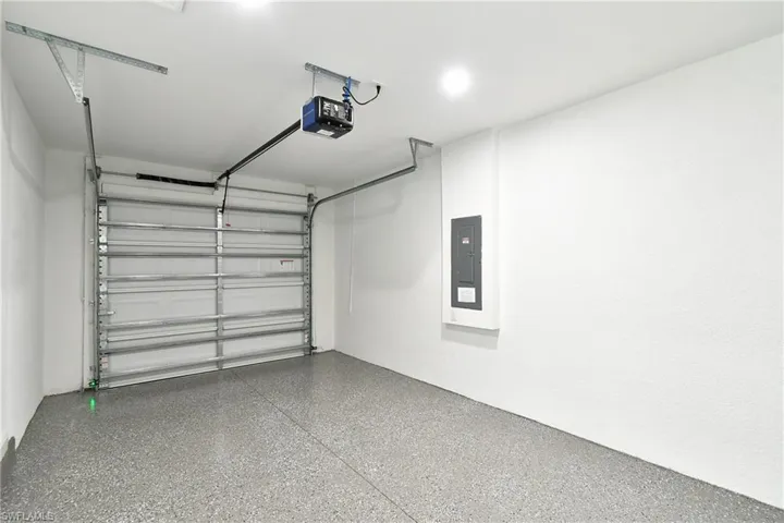 Garage featuring electric panel and a garage door opener