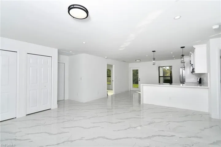 Unfurnished living room featuring recessed lighting and light marble finish floors