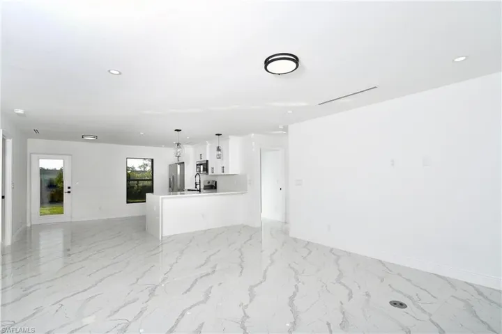 Unfurnished living room featuring recessed lighting and light marble finish floors