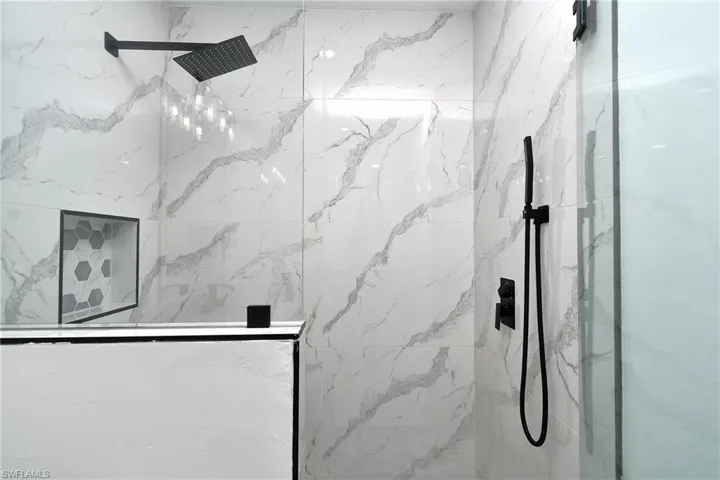 Bathroom featuring a marble finish shower