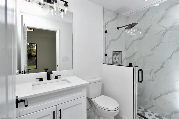 Full bath with vanity and a marble finish shower