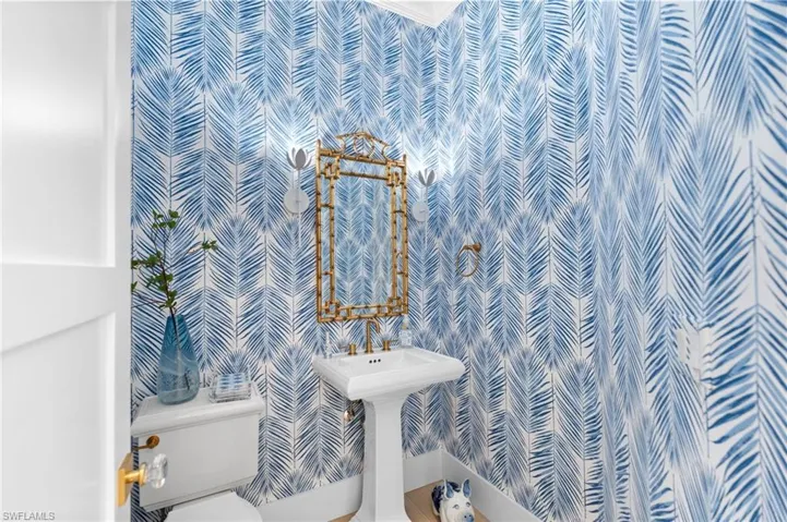 Bathroom featuring toilet and wallpapered walls