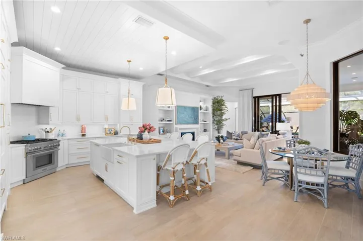 Kitchen featuring white cabinets, a breakfast bar, light wood-type flooring, and stainless steel range