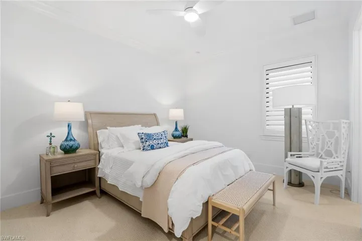 Bedroom with crown molding, carpet, and a ceiling fan
