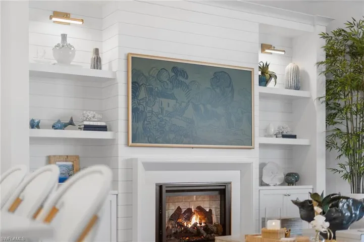 Detailed view of built in shelves and a lit fireplace