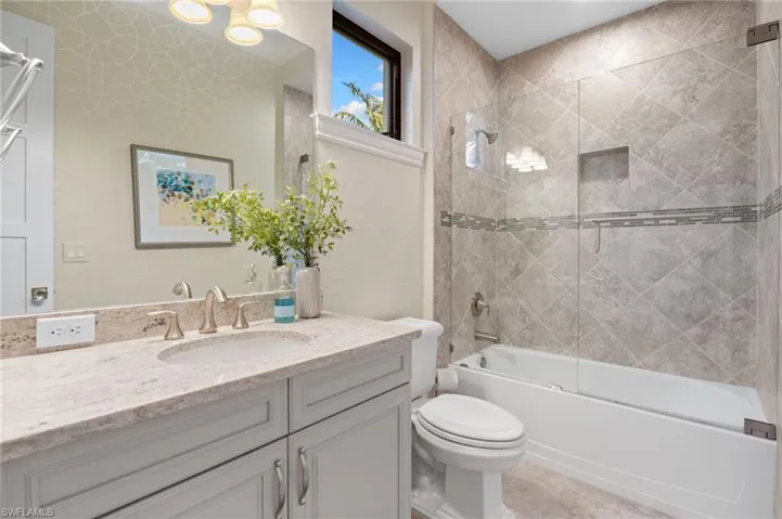 Full bathroom featuring bath / shower combo with glass door and vanity