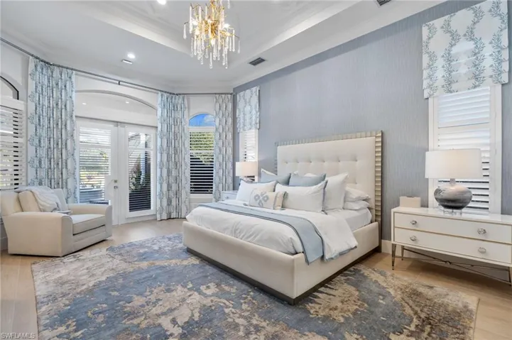 Bedroom with wood finished floors, access to exterior, wallpapered walls, french doors, and ornamental molding