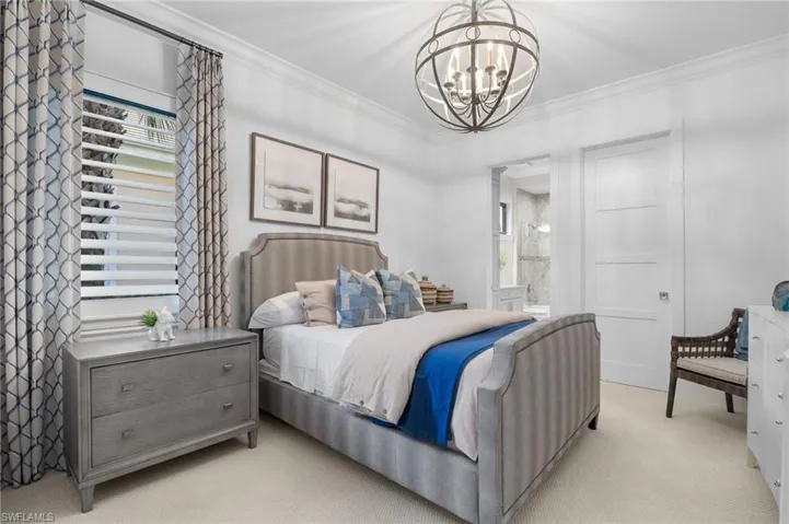 Bedroom featuring ornamental molding, a chandelier, carpet floors, and ensuite bathroom