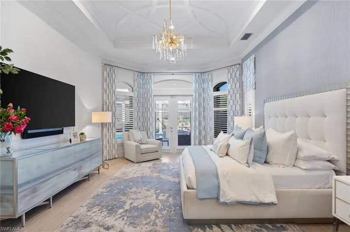 Bedroom featuring french doors, access to outside, wood finished floors, suspended lighting, and crown molding