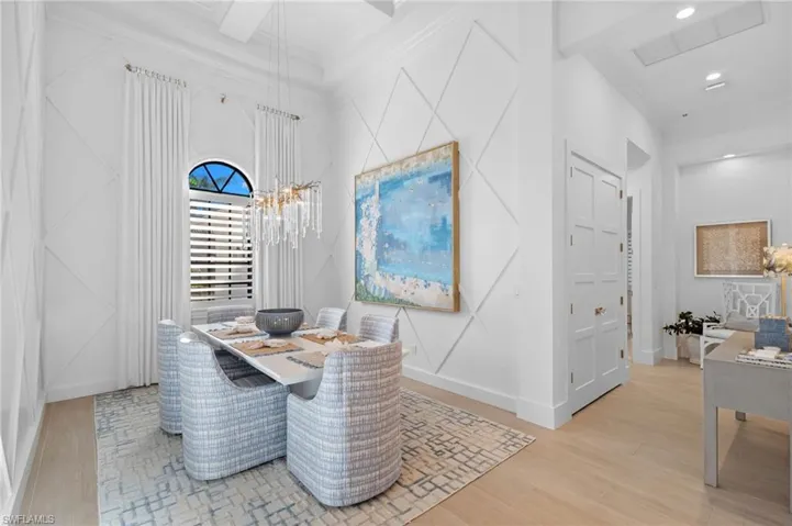 Dining room featuring ornamental molding, light wood-style flooring, and suspended lighting