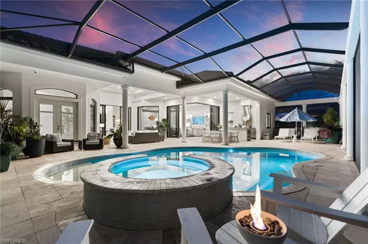 Relaxing pool / spa with a patio, french doors, an outdoor living / dining area, and glass enclosure