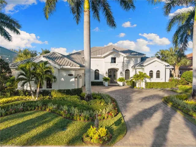 Mediterranean / spanish home featuring stucco siding, curved driveway, a front lawn, a tiled roof, and an attached garage