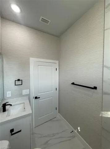 Bathroom with vanity and light marble finish floors