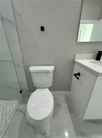 Full bathroom featuring light marble finish flooring, vanity, and a walk in shower