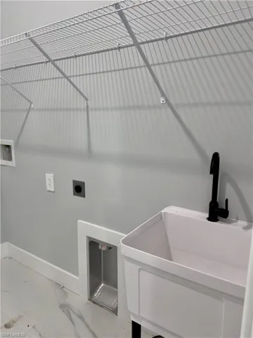 Laundry area with marble look tile flooring, washer hookup, and electric dryer hookup