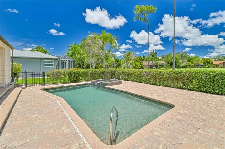 View of pool with a patio and a pool with connected hot tub