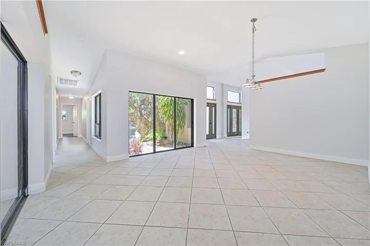 Empty room with light tile patterned floors and recessed lighting