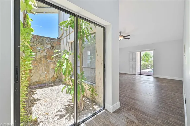 Doorway to outside featuring wood finished floors and a ceiling fan