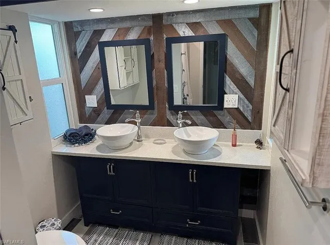 Bathroom with double vanity and wooden walls