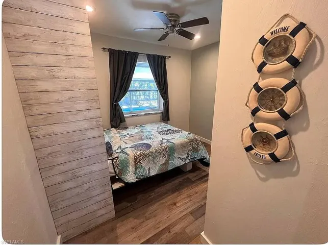 Full bath featuring wood finished floors, a stall shower, double vanity, and a textured ceiling