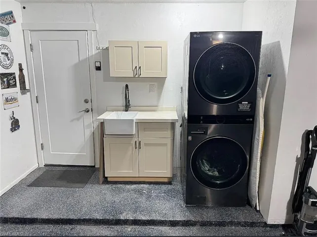 Washroom featuring estacked washer and dryer and cabinet space