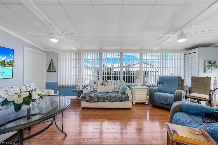 Living room with hardwood / wood-style floors, ceiling fan, and plenty of natural light